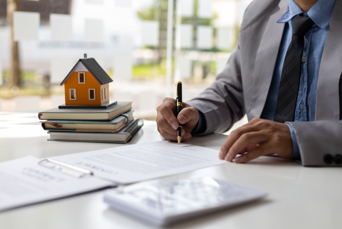 Businessman signs a contract to sell the house legally.