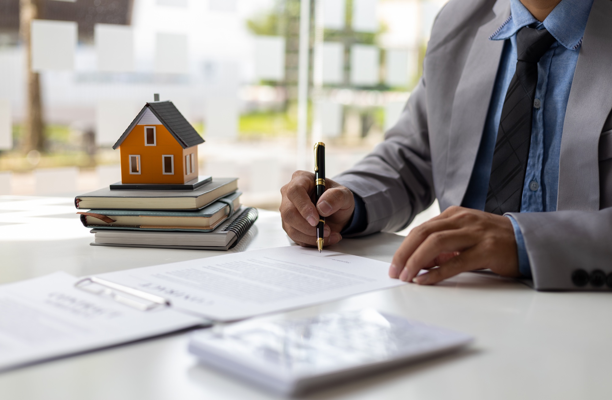 Businessman signs a contract to sell the house legally.